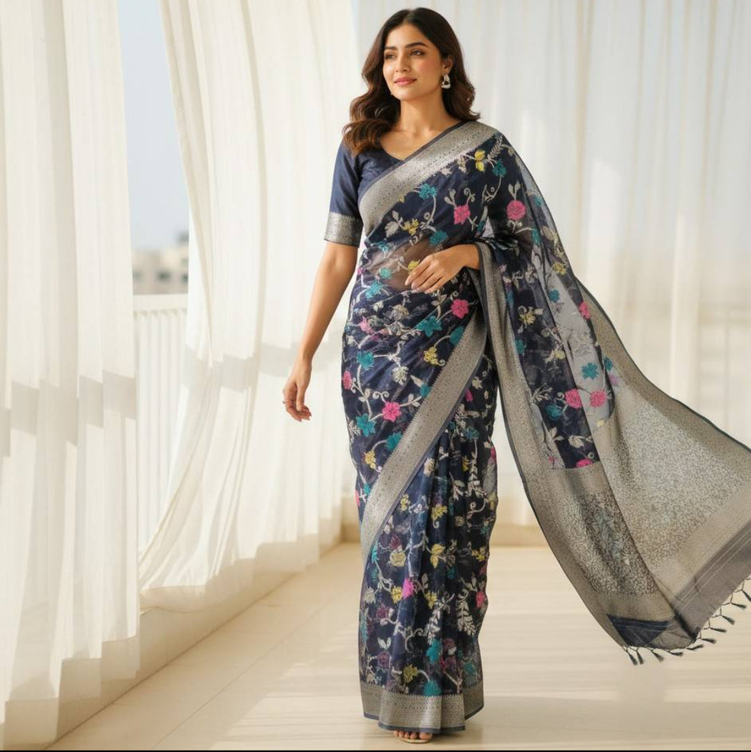 Woman wearing a black organza floral saree indoors.