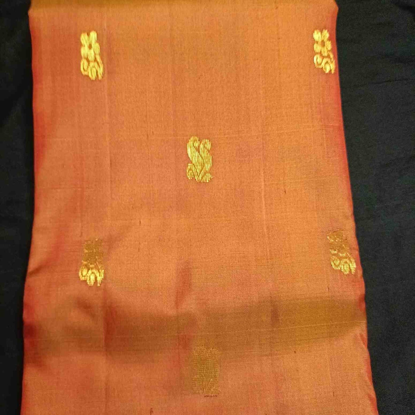 Poo flower motifs with Rettai Mayil peacock forms on earthy orange Kanjivaram silk