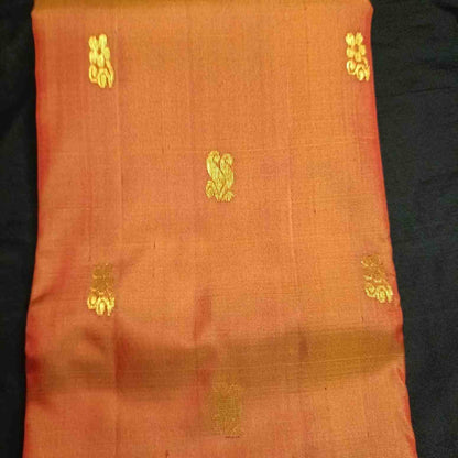 Poo flower motifs with Rettai Mayil peacock forms on earthy orange Kanjivaram silk