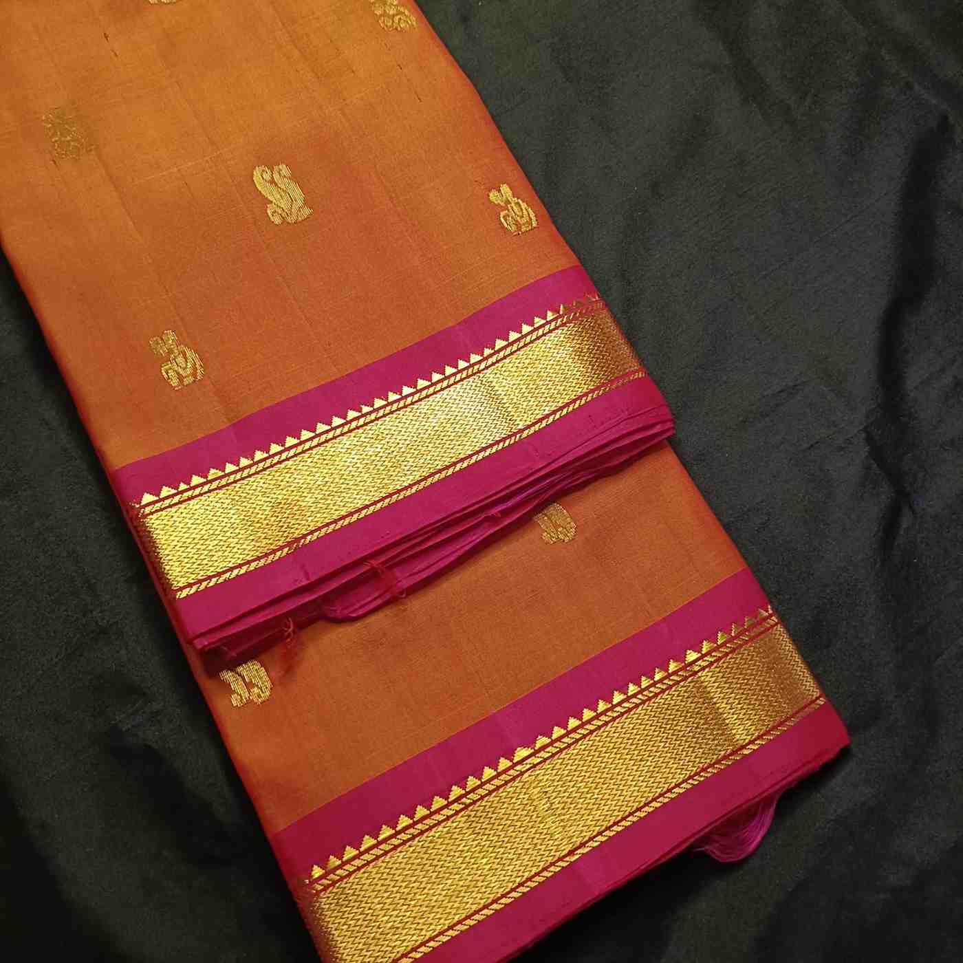 Traditional saw-tooth Bhavanji border detail on earthy orange Kanjivaram saree