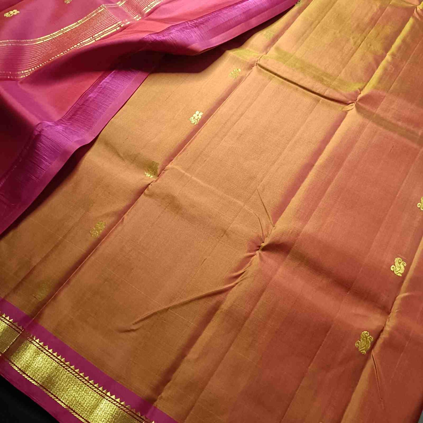 Pure silk Kanjivaram fabric showing earthy Kavi rust orange temple tone