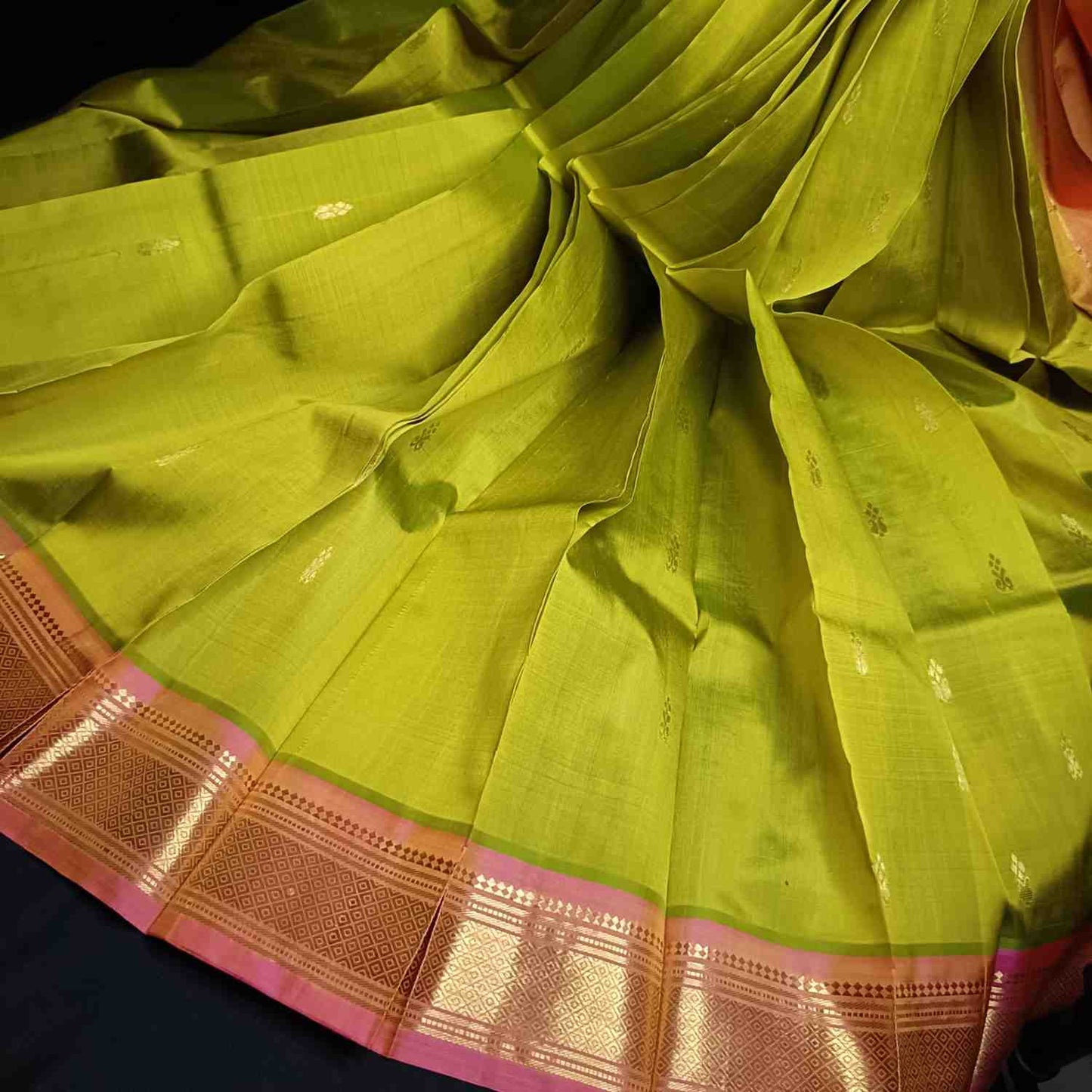 Pure mulberry silk Thirubhuvanam fabric showing vibrant parrot green color