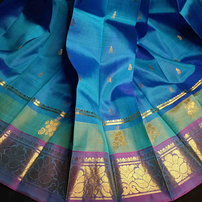 Handloom Thirubhuvanam pure silk saree texture showing poo motifs in antique zari on peacock blue body