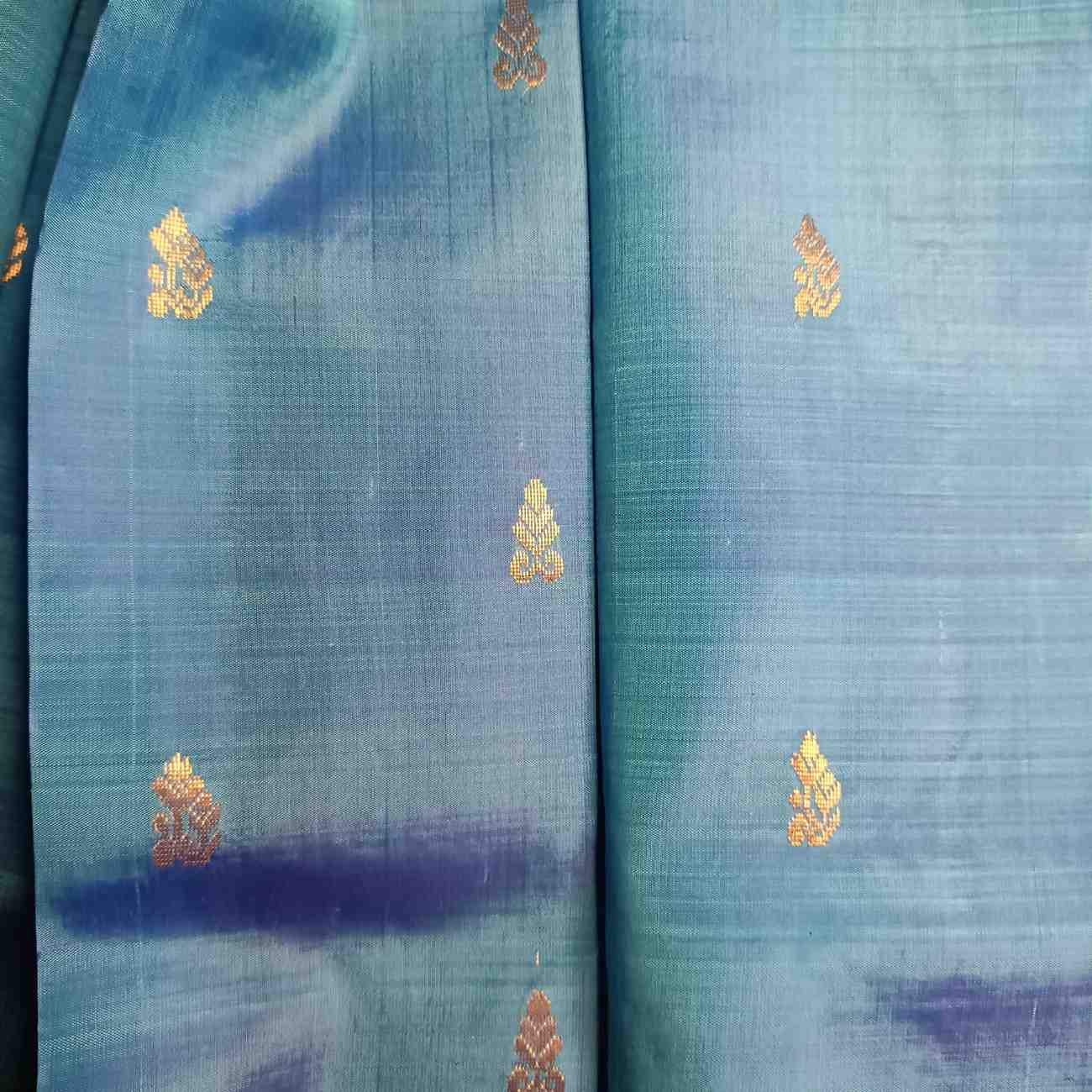Handloom Thirubhuvanam pure silk saree texture showing poo motifs in antique zari on peacock blue body