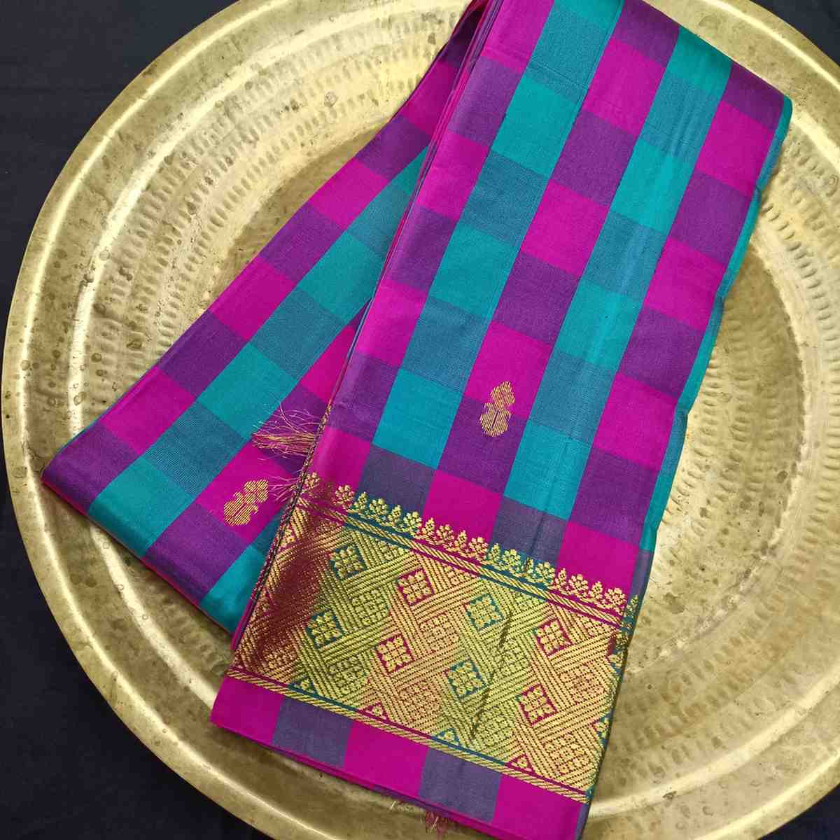 Checkered fabric with purple and teal stripes on a gold plate