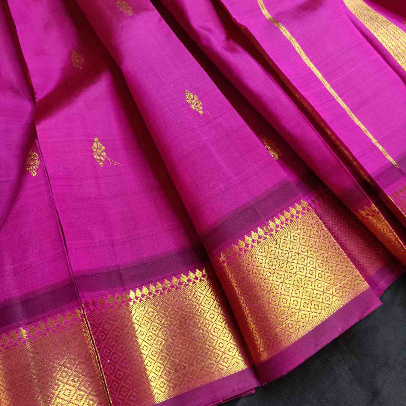 Pink saree with gold patterns on a black background