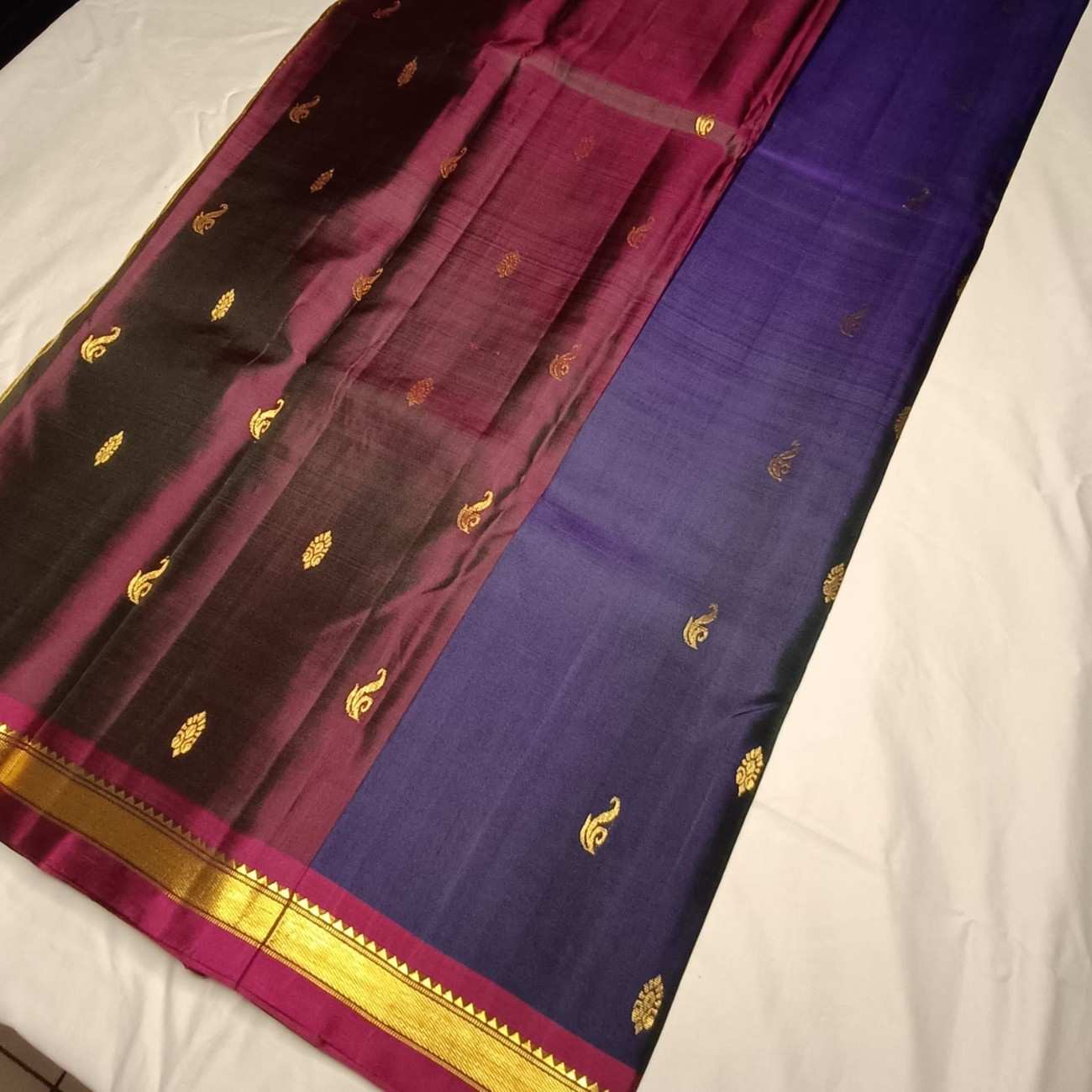 Image 1: Pure handloom navy blue Kanjivaram silk saree with Vanki Butta motifs full view

Image 2: Close-up of contrast Arakku-Paaku wine temple border on navy blue Kanjivaram saree

Image 3: Traditional Saada Vanki Butta motifs with Kasam Butta fillers on navy silk

Image 4: Navy blue Kanjivaram silk saree pallu in Arakku-Paaku wine with zari lines

Image 5: Pure mulberry silk Kanjivaram fabric showing deep navy blue tonal weave

Image 6: Contrast wine blouse piece with navy blue Kanjivaram silk saree

Ima